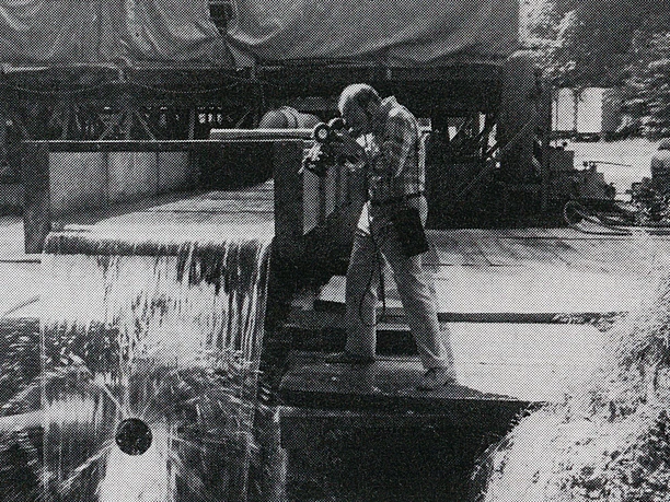 Alexander-von-Humboldt-Quelle Ein Mann fotografiert die sprudelnde Alexander-von-Humboldt-Quelle inmitten einer bewaldeten Umgebung.