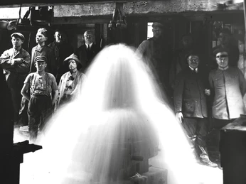 Eine Gruppe von Arbeitern steht um einen sprudelnden Brunnenkopf, aufgenommen im Jahr 1926.