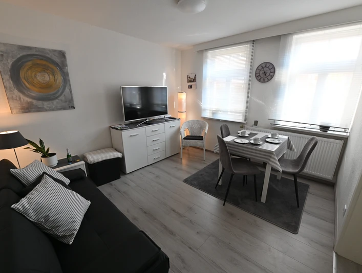 ferienhaeuschen_an_der_stadtmauer_essbereich.jpg Wohnbereich mit Essplatz, Sofa und FernseherLiving area with dining area, sofa and TV