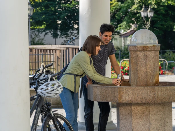 BadLippspringe-Lippequelle-Teutoburger-Wald-Tourismus-Patrick-Gawandtka-019.jpg <p>Ein Paar genießt frisches Wasser an einem Trinkbrunnen in einem sonnigen Park in Bad Lippspringe.</p>
