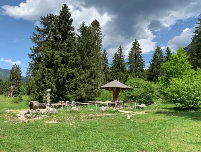 Brunnen mit Sitzbank am Ried