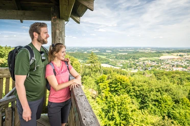 Borgholzhausen-Luisenturm-Teutoburger-Wald-Tourismus-D-Ketz-064.jpg Ein Paar steht auf einem Aussichtsturm, genießt weite Ausblicke über grüne Wälder und Landschaften.