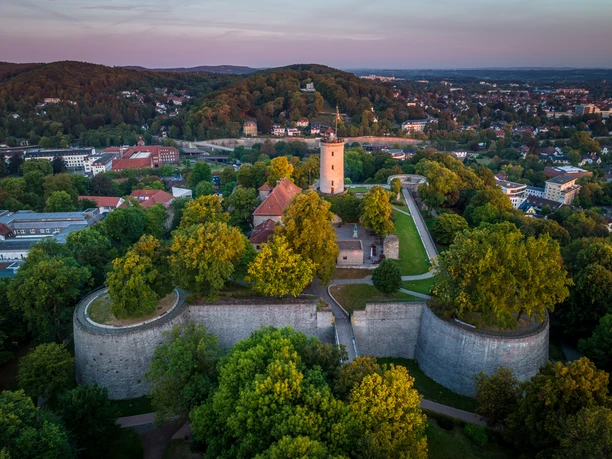 Bielefeld-Sparrenburg-Teutoburger-Wald-Tourismus-D-Ketz-008.jpg <p>Luftaufnahme der Sparrenburg Bielefeld, umgeben von grünen Bäumen, im Sonnenuntergang.</p>