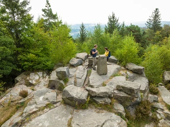 Lippischer Velmerstot-Kreis Lippe-Teutoburger-Wald-Tourismus-D-Ketz-026.jpg Zwei Wanderer bei einer Pause auf einem Felsenplateau mit Aussicht inmitten eines bewaldeten Gebiets.