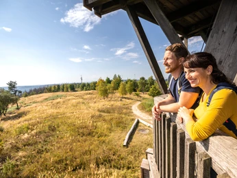 Preußischer Velmerstot-Kreis Lippe-Teutoburger-Wald-Tourismus-D-Ketz-048.jpg Ein lächelndes Paar betrachtet von einem hölzernen Aussichtspunkt aus die weitläufige Landschaft.