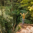 Lichtenau-Alte Eisenbahn-Teutoburger-Wald-Tourismus-D-Ketz-062.jpg Ein Mann steht mit offenen Armen am Waldrand und blickt in eine bewaldete Schlucht.