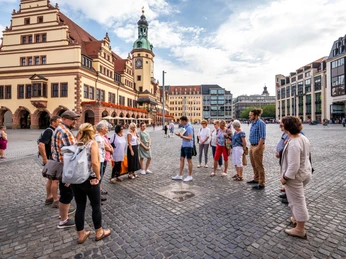 Gruppenführung am Leipziger Marktplatz vor dem Alten Rathaus - Stadtführung zur Geschichte Leipzigs Eine Gruppe steht im Sommer in einem Kreis am Leipziger Marktplatz vor dem Alten Rathaus