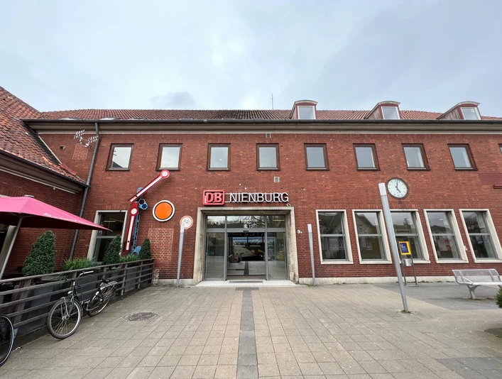Bahnhof Nienburg Zweistöckiges Backsteingebäude des Bahnhofs Nienburg mit stilvollem DB-Schild über dem Eingang.
