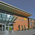 BFL aussen029.jpg Moderne Backsteinfassade des Bonifatius Hospitals Lingen mit gläsernem Haupteingang und Vorplatz.