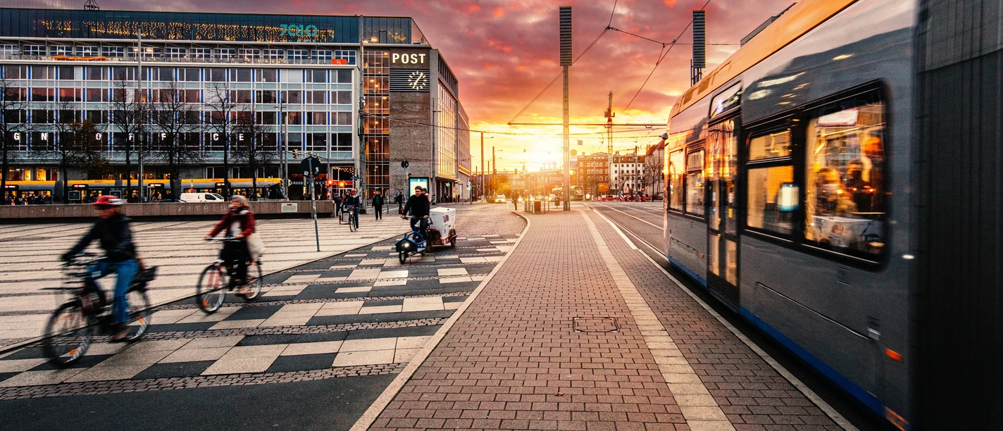 Augustusplatz Leipzig mit Straßenbahn und Radfahrern | Leipzig Convention Bureau Auf dem Augustusplatz in Leipzig fährt eine Straßenbahn und Radfahrer sind unterwegs – präsentiert vom Leipzig Convention Bureau