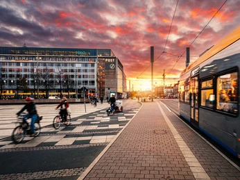 Augustusplatz Leipzig mit Straßenbahn und Radfahrern | Leipzig Convention Bureau Auf dem Augustusplatz in Leipzig fährt eine Straßenbahn und Radfahrer sind unterwegs – präsentiert vom Leipzig Convention BureauA tram runs along Augustusplatz in Leipzig and cyclists are on the move – presented by the Leipzig Convention Bureau