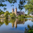 Die Mulde vor dem Schloss Rochlitz - Schlösser der Leipzig Region Gesamtansicht des Schloss Rochlitz mit der Mulde im Vordergrund, umrahmt von grünen Bäumen, Mulderadweg, Lutherweg Sachsen