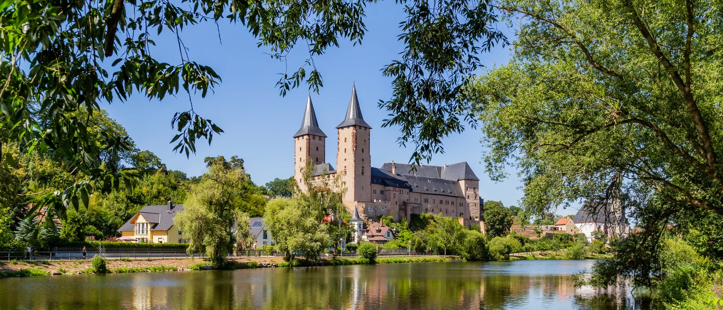 Die Mulde vor dem Schloss Rochlitz - Schlösser der Leipzig Region Gesamtansicht des Schloss Rochlitz mit der Mulde im Vordergrund, umrahmt von grünen Bäumen, Mulderadweg, Lutherweg Sachsen