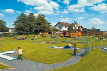 Familienfreundliches Café mit Spielplatz in ländlicher Umgebung und sonnigem Wetter im Sommer.