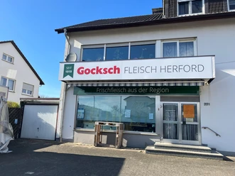 Fassade der Fleischerei Gocksch mit großem Schild und Schaufenster bei Sonnenschein