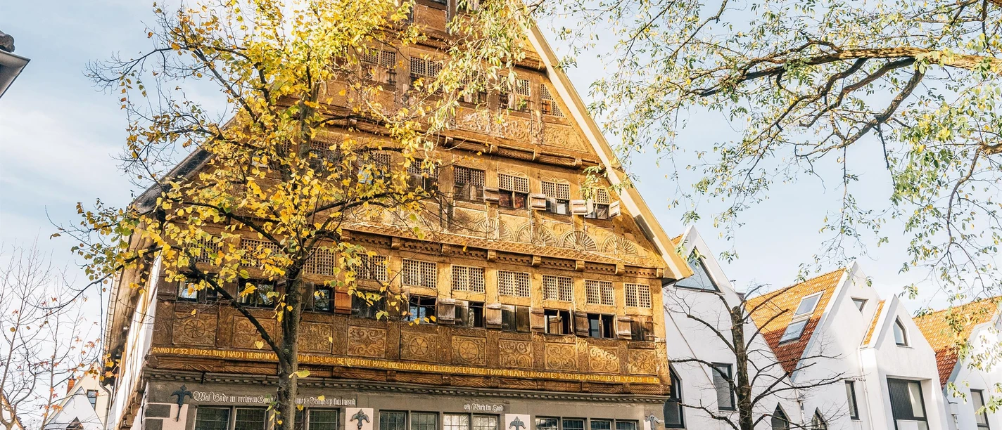 Historisches Haus Backs mit verzierter Holzfassade und Herbstbäumen in Bad Salzuflen