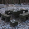 Steinerner-Tisch Steinerner Tisch mit Bänken im verschneiten Wald, umgeben von Laub und kahlen Bäumen, in ruhiger, winterlicher Atmosphäre.Stone table with benches in the snowy forest, surrounded by leaves and bare trees, in a quiet, wintry atmosphere.Kamenný stůl s lavicemi v zasněženém lese, obklopený listím a holými stromy, v tiché zimní atmosféře.Kamienny stół z ławkami w zaśnieżonym lesie, otoczony liśćmi i nagimi drzewami, w spokojnej, zimowej atmosferze.Stenen tafel met banken in een besneeuwd bos, omringd door bladeren en kale bomen, in een rustige, winterse sfeer.Tavolo in pietra con panche in un bosco innevato, circondato da foglie e alberi spogli, in un'atmosfera tranquilla e invernale.