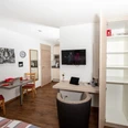 Apartment Alme_Raum.jpg Modern eingerichtetes Apartment mit Holzboden, Esstisch, Küchenzeile, Kleiderschrank und TV.