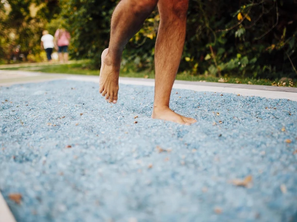 Barfußpfad Mann geht über blaue Steine