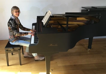 Annette Liss am Haessler-Flügel Annette Liss spielt auf einem schwarzen Haessler-Flügel in hellem Raum.
