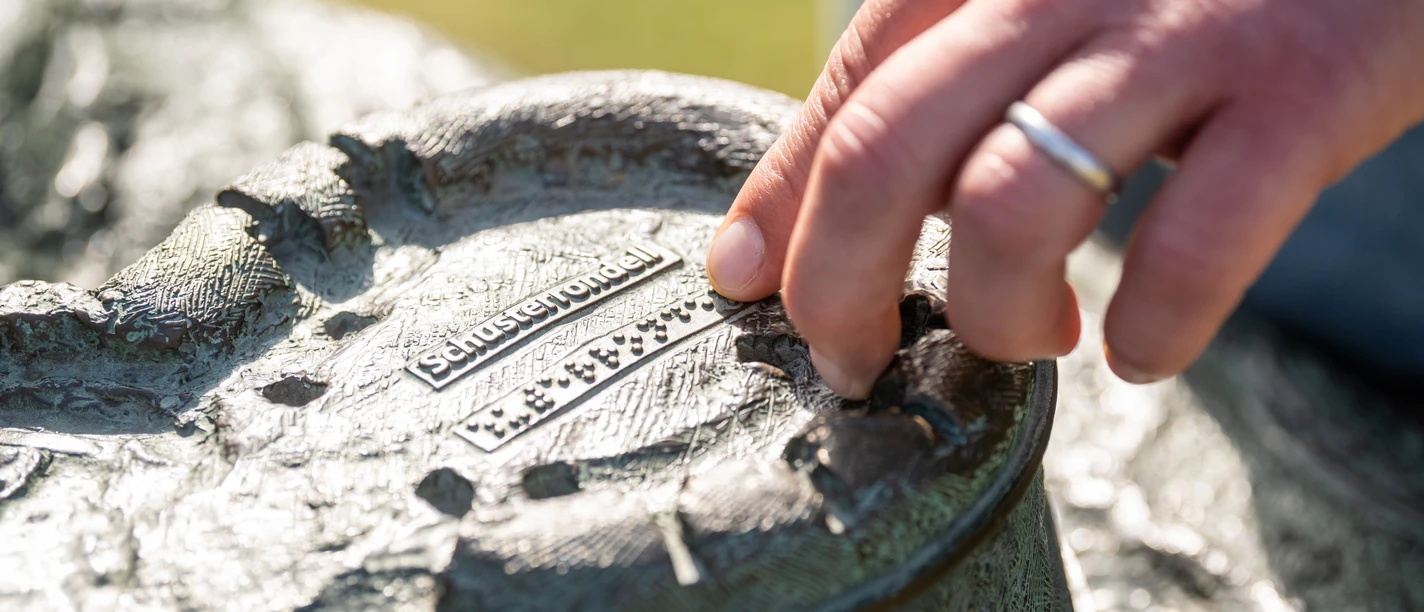 Bielefeld-Sparrenburg-Teutoburger-Wald-Tourismus-D-Ketz-037-2.jpg Skulptur eines Plans mit taktilen Elementen, Lesender Finger ertastet Brailleschrift auf Metall.