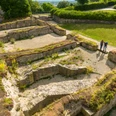 Bielefeld-Sparrenburg-Teutoburger-Wald-Tourismus-D-Ketz-030-2.jpg Ruinen eines antiken Gebäudes, umgeben von grüner Landschaft; drei Menschen betrachten die Überreste.