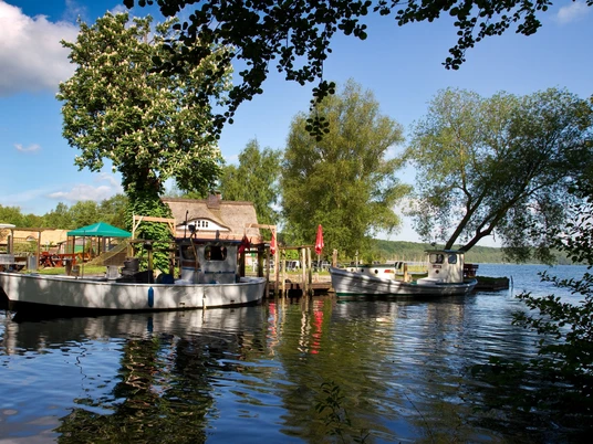 Fischerei Jobmann, Jens Butz.jpg Blick vom Wasser auf die Fischerei mit mehreren Booten