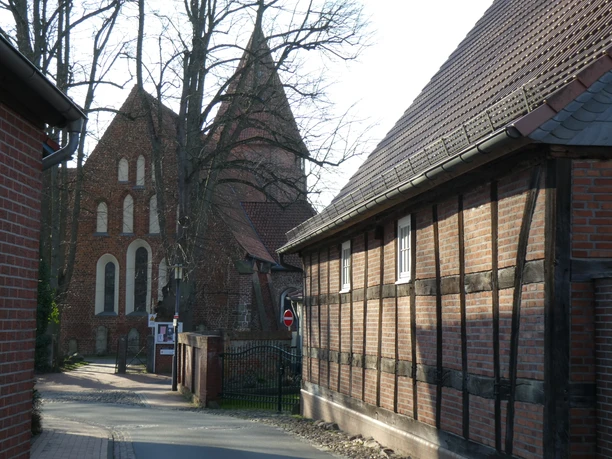 Straßenansicht in einem niedersächsischen Dorf mit historischen Backsteingebäuden und Kirche.