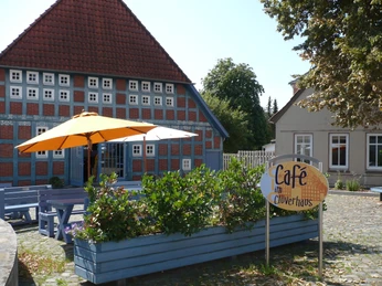 Clüverhaus: Historisches Gebäude mit rotem Ziegeldach, blauem Holzfachwerk und einladendem Café.