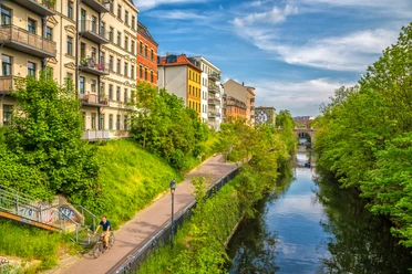 Karl-Heine-Kanal in der Wasserstadt - Fahrrad und Kanufahren in Leipzig Grünende Bäume am Karl-Heine-Kanal im Sommer, bunte Häuser, blauer Himmel, Wasser