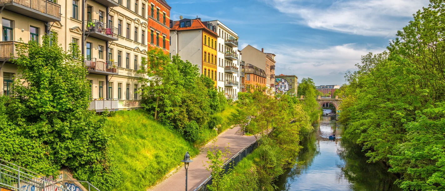 Karl-Heine-Kanal in der Wasserstadt - Fahrrad und Kanufahren in Leipzig Groene bomen op het Karl Heine kanaal in de zomer, kleurrijke huizen, blauwe lucht, water
