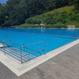 Freibad Büren Freibad Büren: Modernes Schwimmbecken umgeben von Grüngürtel und Zugangstreppe am Beckenrand.