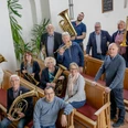Posaunenchor Pilsum Posaunenchor aus zwölf Personen mit Instrumenten zwischen Kirchenbänken.