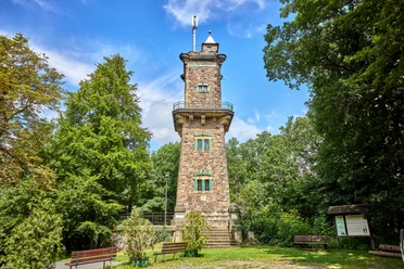 Bismarck Tower op panoramische hoogte: Historische toren van natuursteen midden in een groene bosrijke omgeving.