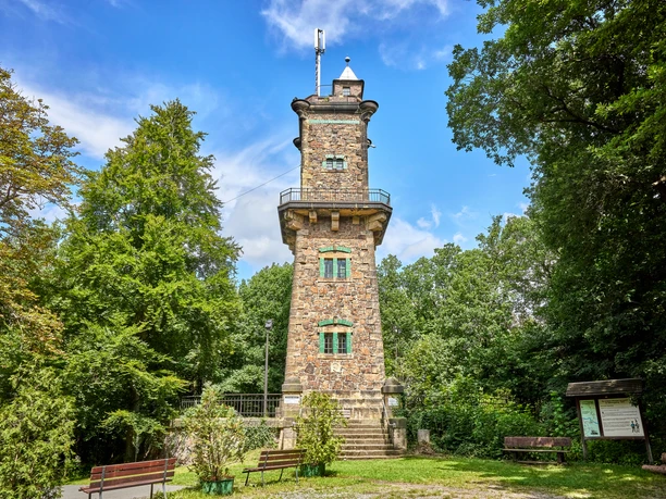 Bismarck Tower at panoramic height: historic tower made of natural stone in the middle of a green wooded area.
