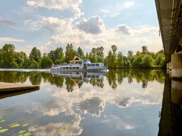 Weiße Flotte, Mülheim an der Ruhr Schiff der Weißen Flotte auf der Ruhr, umgeben von grünen Bäumen und einer Brücke rechts im Bild.