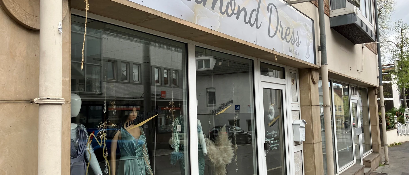 Schaufenster von Diamond Dress by Sara mit festlichen Kleidern und großem Ladenschild