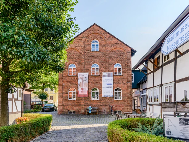 Gütersloh: Stadtmuseum Historisches Backsteingebäude des Stadtmuseums Lemgo, flankiert von Fachwerkhäusern und einem Baum.