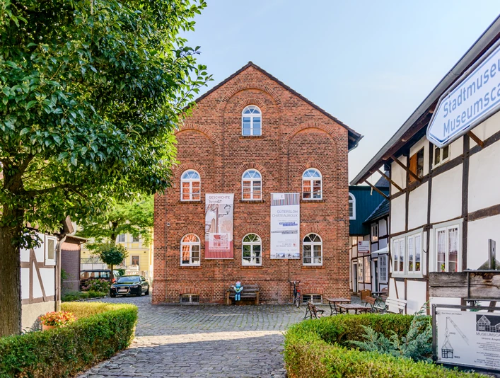 Gütersloh: Stadtmuseum Historisches Backsteingebäude des Stadtmuseums Lemgo, flankiert von Fachwerkhäusern und einem Baum.