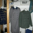 CIMG5700.JPG Historische Uniformen und Mäntel im Raum ausgestellt, mit Fotos und Dekorationen an den Wänden.