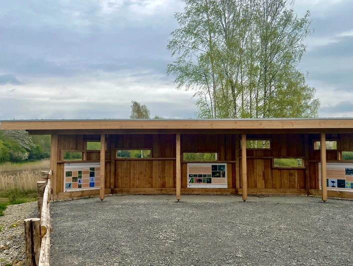 Ein hölzerner Unterstand mit Infotafeln bietet Ausblick auf die Natur und renaturierte Tongruben.