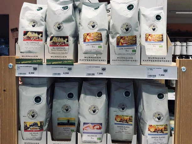 Dorfladen Grafenaschau Verschiedene Kaffeesorten der Murnauer Kaffeerösterei auf einem Verkaufsregal.