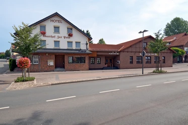 GzP_Aussenansicht02_c_GzP.jpg Hotel mit Backsteinfassade und traditionellen Schriftzügen, gelegen an einer ruhigen Straße.