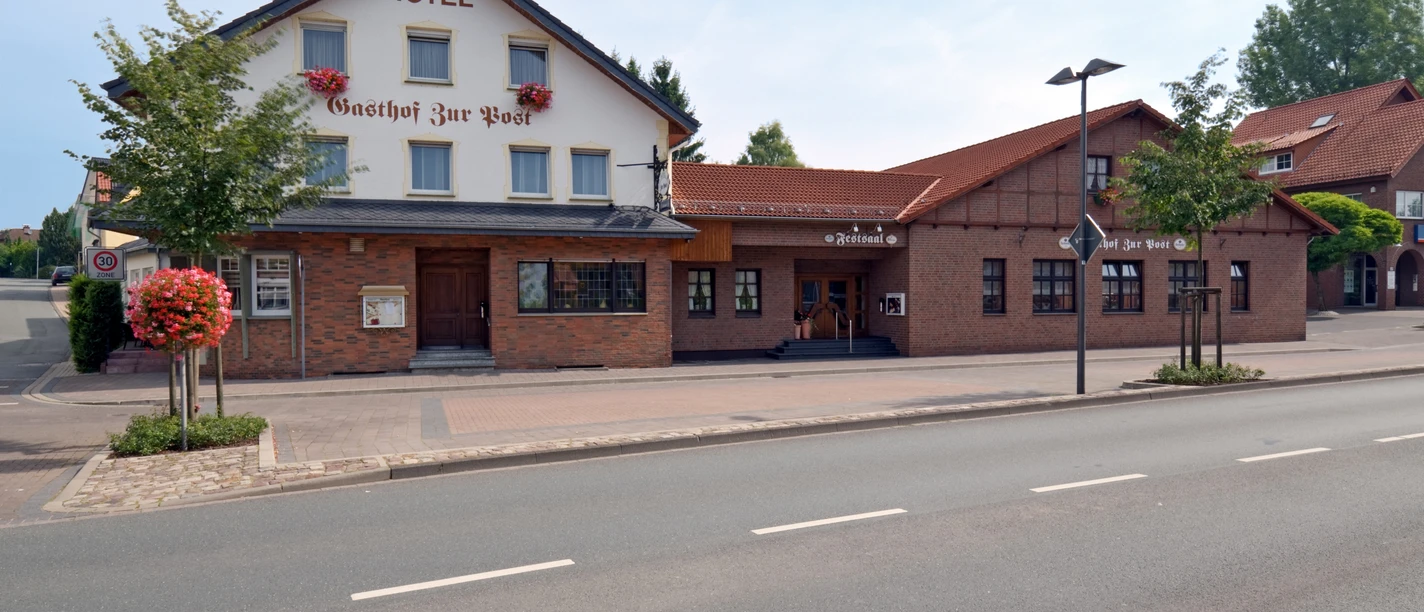GzP_Aussenansicht02_c_GzP.jpg Hotel mit Backsteinfassade und traditionellen Schriftzügen, gelegen an einer ruhigen Straße.