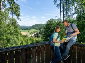 Altenbeken-kleinesViadukt-Aussichtsplattform-Teutoburger-Wald-Tourismus-Patrick-Gawandtka-056__lowres.jpg Zwei Personen stehen auf einer Aussichtsplattform im Teutoburger Wald, mit Blick auf ein Viadukt.