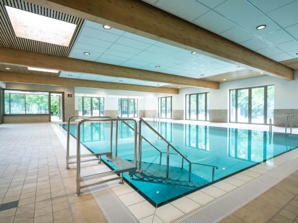 Sielbad Bad Oeynhausen Lichtdurchflutetes Hallenbad mit großen Fenstern, modernem Edelstahlbecken und breiter Einstiegstreppe.