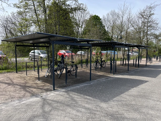 Fahrradabstellanlage in Greetsiel Überdachte Fahrradabstellanlage mit mehreren Fahrradständern neben einer Straße in Greetsiel.