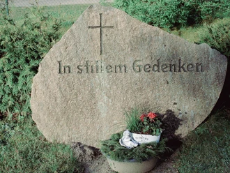 firedhöfe im der samtgemeinde_.jpg Naturstein mit eingemeißeltem Kreuz und Schriftzug In stillem Gedenken sowie kleinem Blumenschmuck.