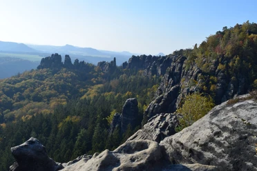 Aussicht Breite Kluft Felsformationen und bewaldete Hügel unter klarem Himmel in einer herbstlichen Landschaft, die eine ruhige und majestätische Atmosphäre ausstrahlt.
