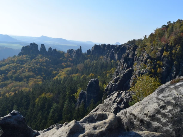 View Wide Gap Rock formations and wooded hills under a clear sky in an autumnal landscape that exudes a calm and majestic atmosphere.